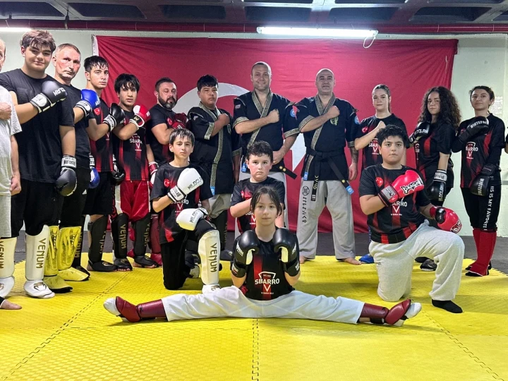 Arena 14 Fight Club bünyesindeki sporcular antrenman salonunda toplu halde poz veriyor