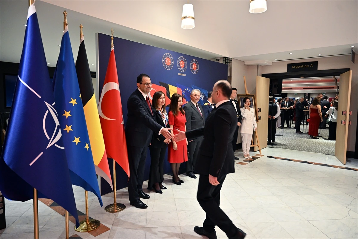 Brüksel’de Cumhuriyet Bayramı resepsiyonunda Türk ve Avrupa bayraklarının önünde konukları karşılayan temsilciler