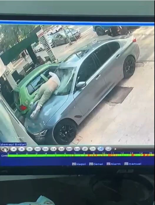 Güvenlik kamerası görüntüsünde kadının otomobilin üzerine düştüğü an görülüyor.