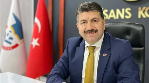 Gazeteci Celal Çiftçi, arkasında Türk bayrağı bulunan bir ofiste otururken