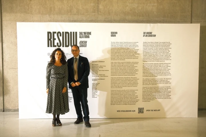 Residui: Atıktan Sanata sergisi tanıtım panosunun önünde duran iki kişi