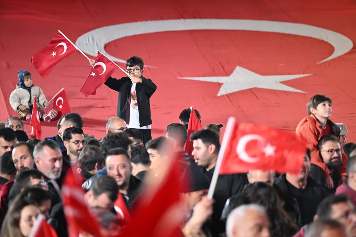 Çocuklar ve vatandaşlar büyük Türk bayrağı önünde bayraklarla kutlamalara katılıyor