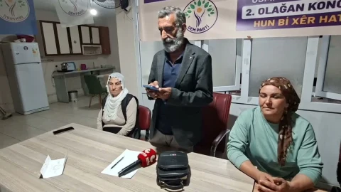 DEM Parti Osmaniye Eş Başkanı Adnan Gökçen, açıklama sırasında partililerle birlikte masada
