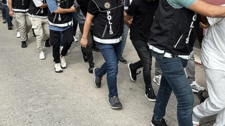 Polis ekipleri, operasyon kapsamında gözaltına alınan kişileri götürüyor