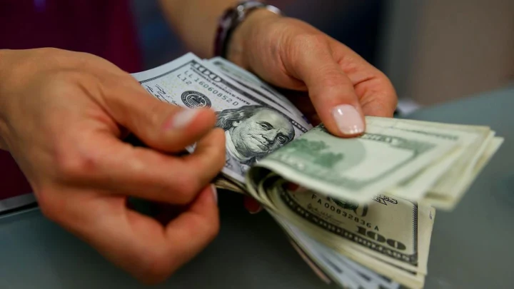 Bir kişinin elinde ABD doları banknotlarını sayması