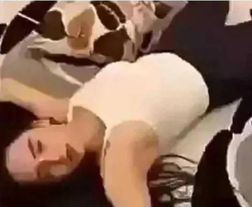 Yerde uzanmış bir kişinin ve çevresindeki kişilerin görüldüğü düşük çözünürlüklü görüntü