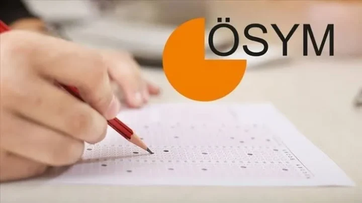 ÖSYM ve YDS yazıları önünde sınav cevap kâğıdını işaretleyen el