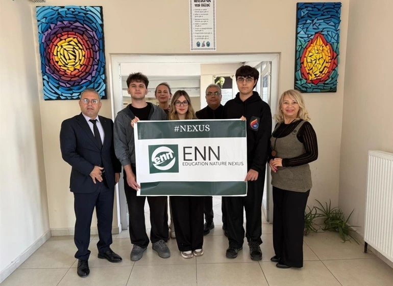 Öğrenciler ve yetişkinler ENN yazılı pankartı tutuyor