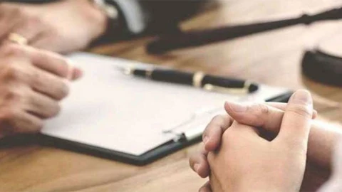 Masa üzerinde evrakları inceleyen kişilerin elleri