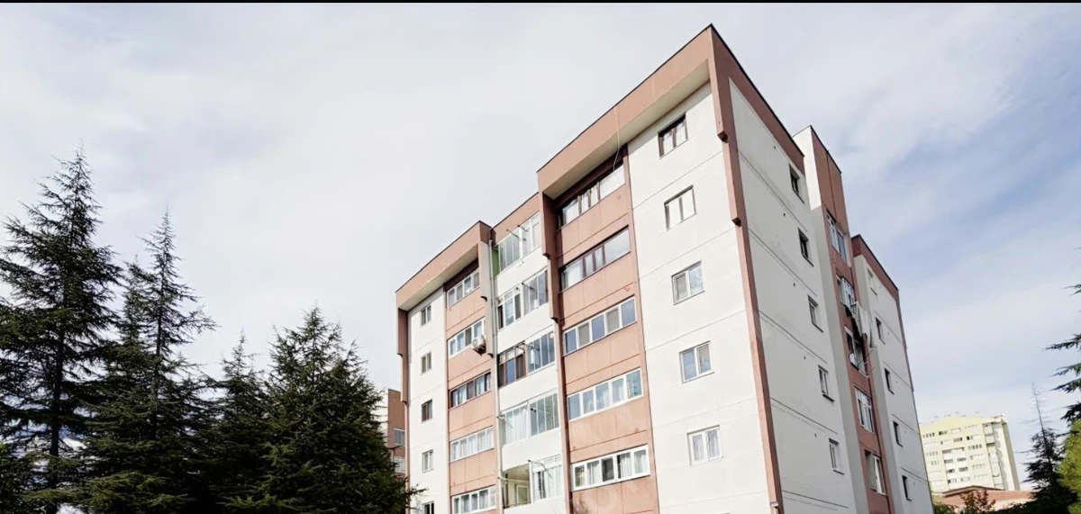 Ağaçların yanında yükselen çok katlı apartman binası