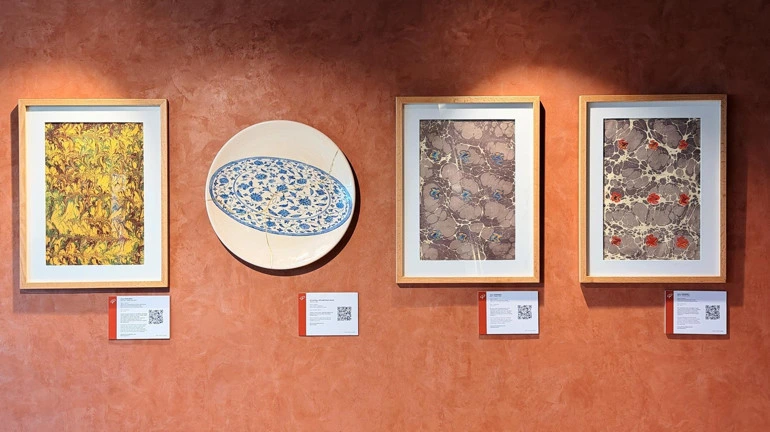 Lounge duvarında sergilenen dört çerçeveli ve tabak biçimli sanat eseri