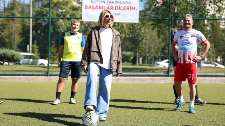 Etimesgut Belediye Başkan Vekili Seda Dilber, halı sahada futbol topunun yanında; iki sporcu arka planda duruyor.
