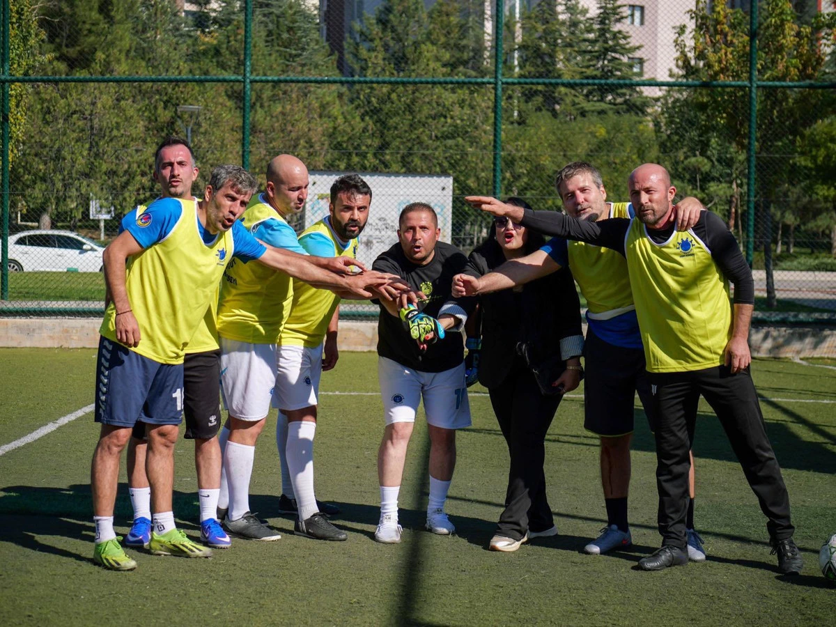 Sarı formalı futbolcular, maç öncesinde saha içinde takım halinde kenetleniyor.