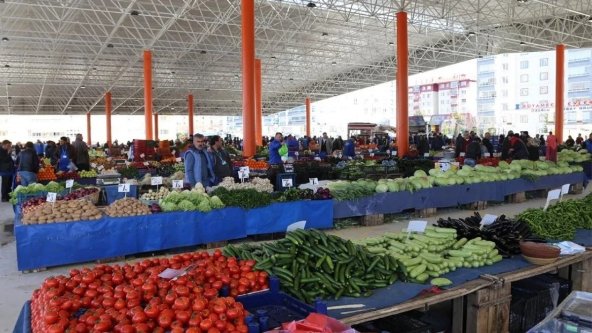 Kapalı pazar alanında tezgâhlarda sebze ve meyveler, alışveriş yapan vatandaşlar