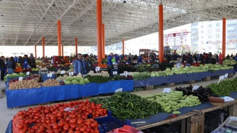 Kapalı pazar alanında tezgâhlarda sebze ve meyveler, alışveriş yapan vatandaşlar