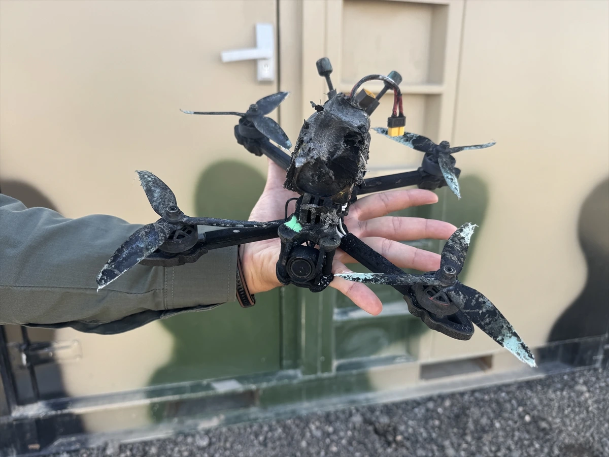 Hasar görmüş bir dron, bir kişinin elinde tutuluyor