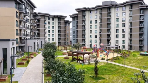 Apartman bloklarının çevresinde yürüyüş yolları ve çocuk oyun alanı bulunan konut sitesi
