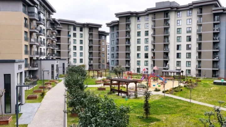 Apartman bloklarının çevresinde yürüyüş yolları ve çocuk oyun alanı bulunan konut sitesi