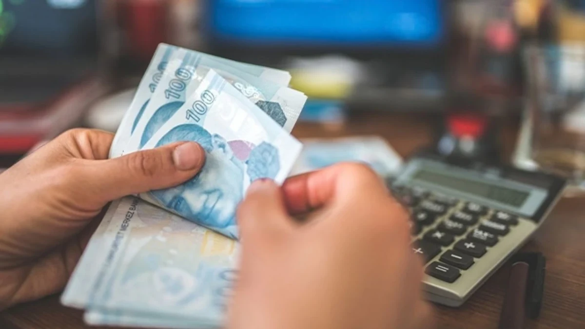 Banknotları sayan eller ve hesap makinesi