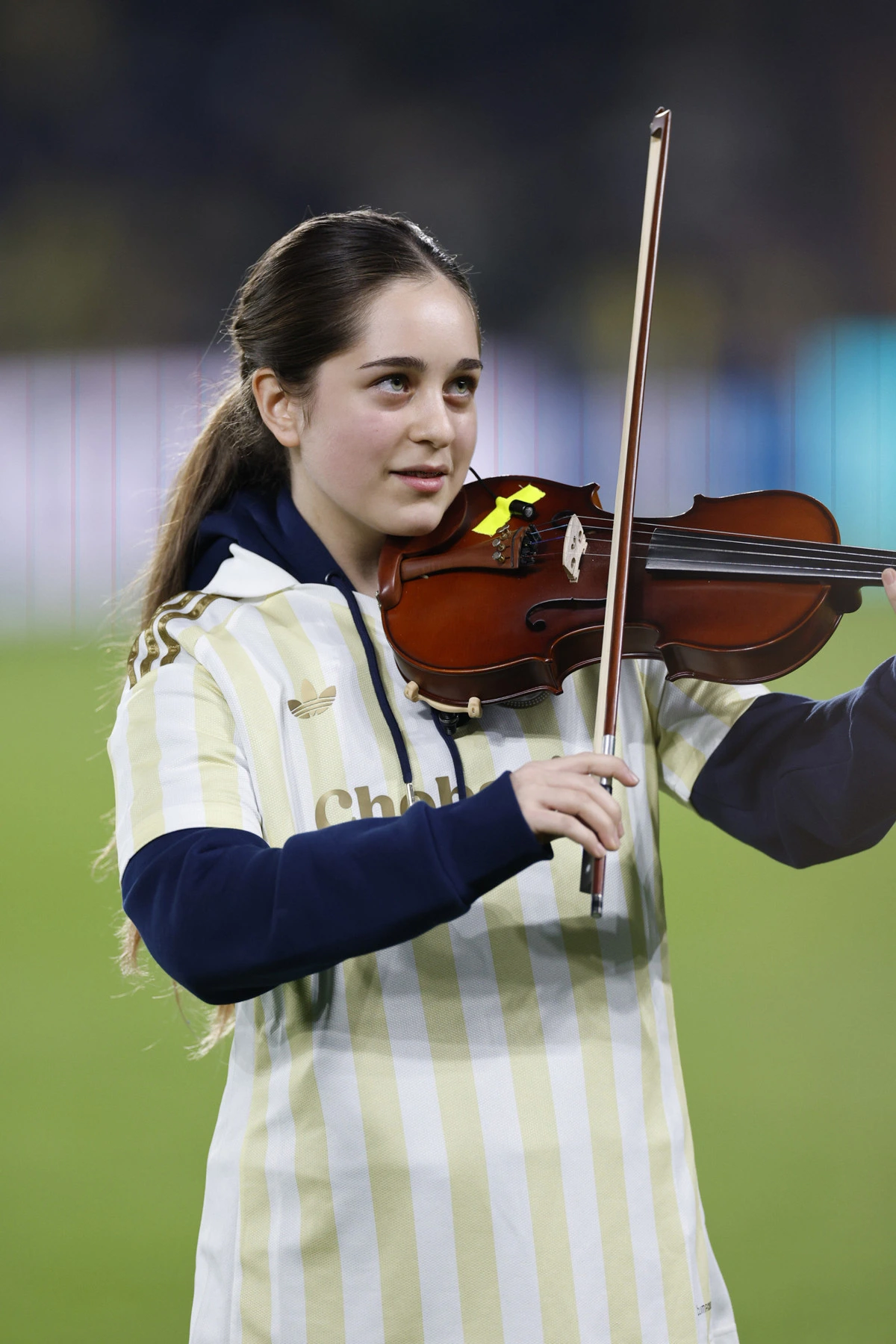 Fenerbahçe renklerini taşıyan kıyafetle keman çalan genç öğrenci