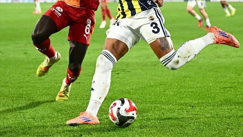 Galatasaray ve Fenerbahçe formaları giyen futbolcuların top mücadelesi