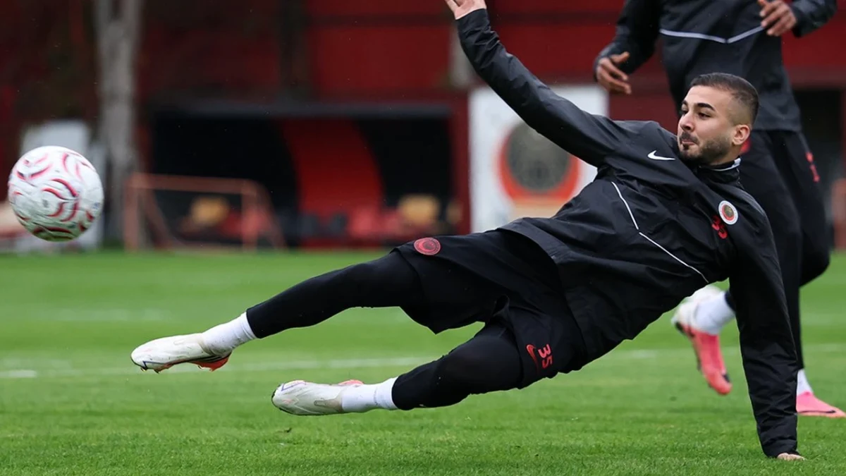 Gençlerbirliği antrenmanında siyah eşofmanlı bir futbolcu sahada topa müdahale ediyor
