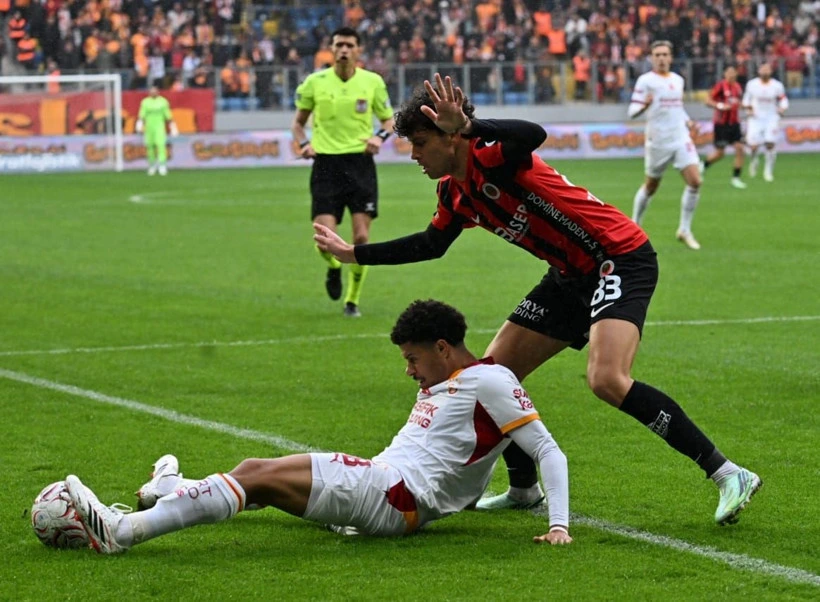 Gençlerbirliği futbolcusu kayarken Galatasaraylı oyuncu topa yöneliyor