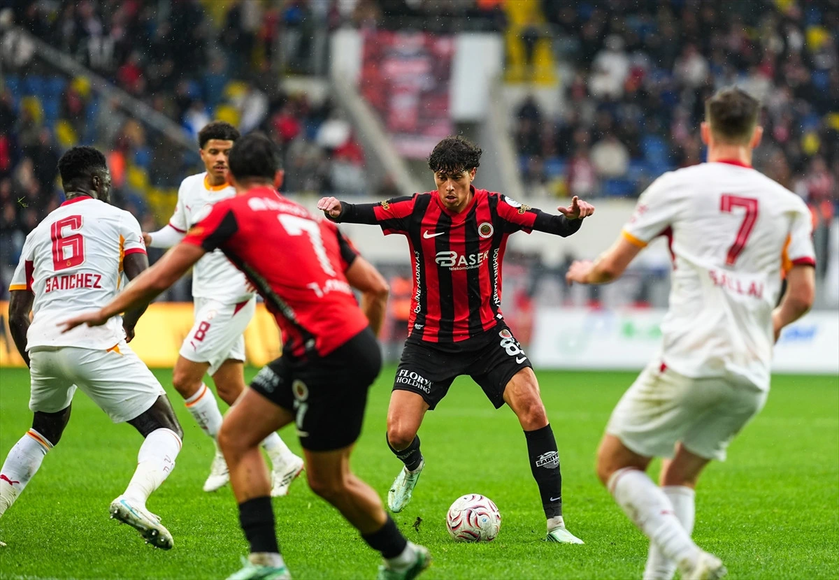 Gençlerbirliği futbolcusu, Galatasaraylı oyuncuların arasında topla ilerliyor