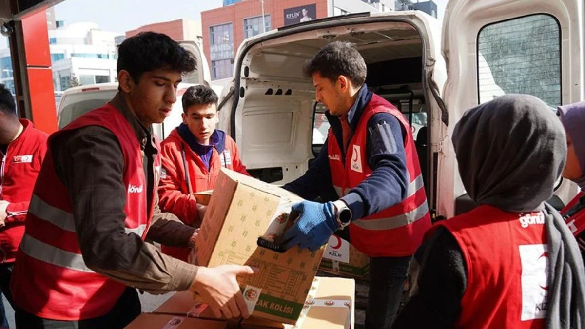 Gönüllüler, bir araçtan yardım kolilerini indiriyor.