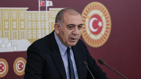 Gürsel Tekin, CHP ambleminin yer aldığı fonda mikrofonların önünde konuşurken