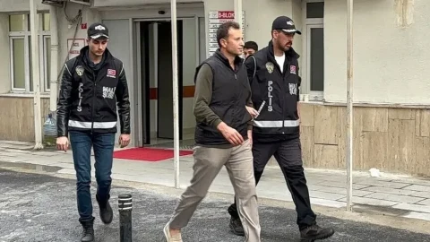 Bir kişi polisler eşliğinde adliye binasından çıkarken