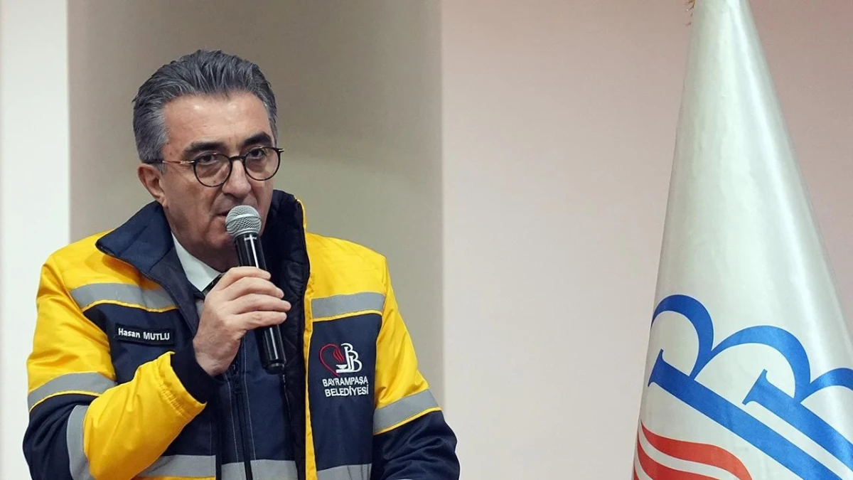 Bayrampaşa Belediye Başkanı Hasan Mutlu, belediye yeleğiyle mikrofonla konuşuyor.