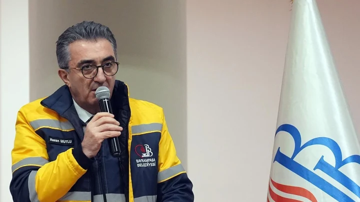 Bayrampaşa Belediye Başkanı Hasan Mutlu, belediye yeleğiyle mikrofonla konuşuyor.