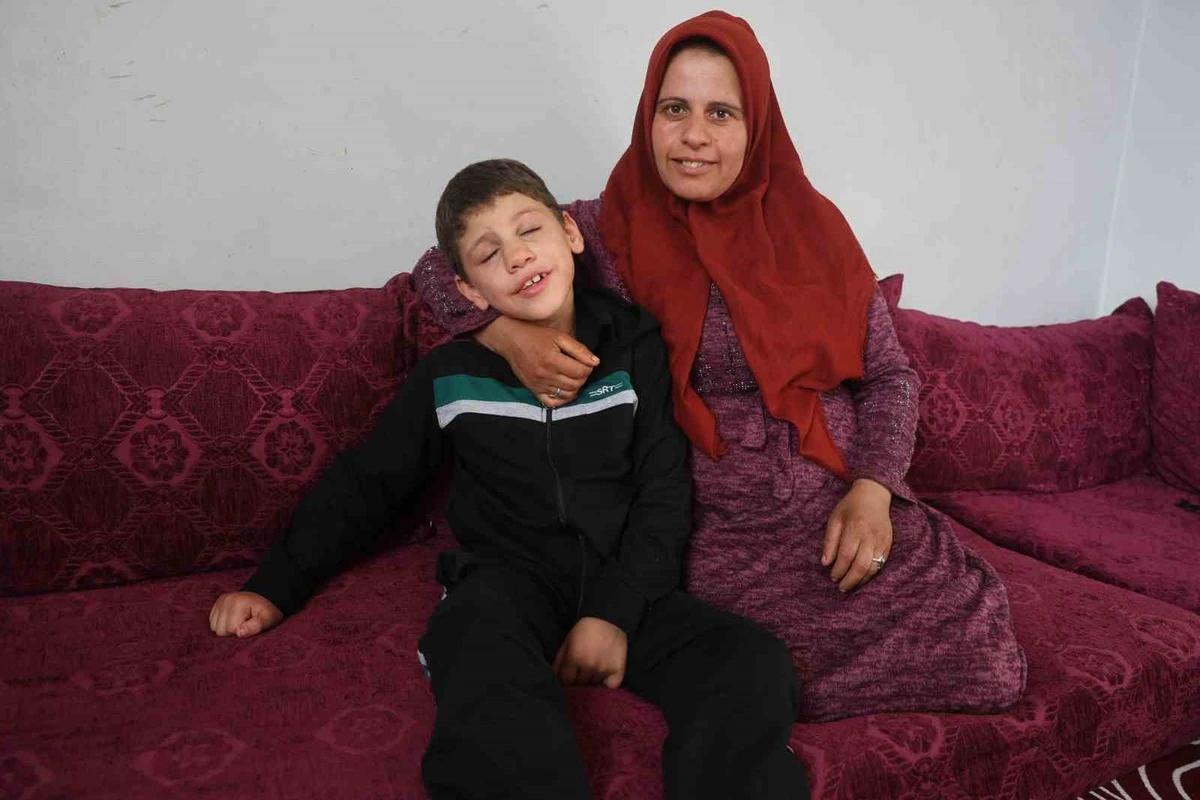 Hataylı çocuk annesiyle birlikte koltukta oturuyor