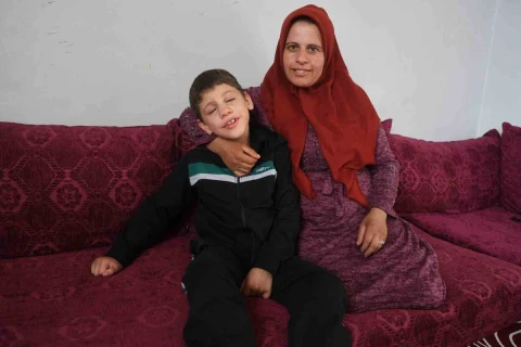Hataylı çocuk annesiyle birlikte koltukta oturuyor