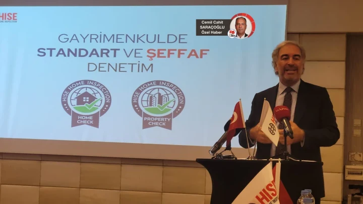 Sinan Özkök, gayrimenkulde standart ve şeffaf denetim konulu sunumun önünde konuşuyor.