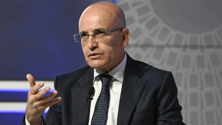 İbrahim Ömer Gönül, takım elbiseyle bir etkinlikte konuşurken