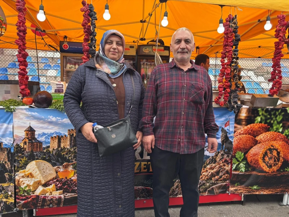 Yöresel ürünler standının önünde duran bir kadın ve bir erkek