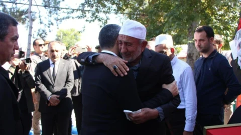 Emekli müftü Adem Ayrancı, cenaze töreninde bir kişiyle kucaklaşıyor