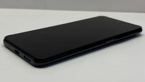Beyaz bir yüzey üzerinde ekranı kapalı siyah akıllı telefon