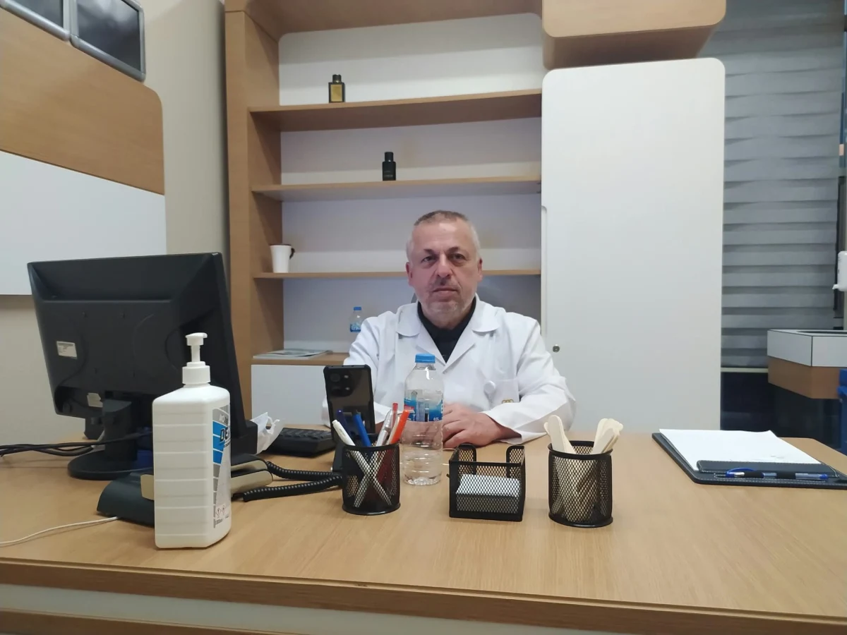 Uzm. Dr. İsmet Battal muayene odasında masasının arkasında oturuyor