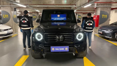 Mali Suçlarla Mücadele ekipleri, otoparkta siyah bir aracın yanında