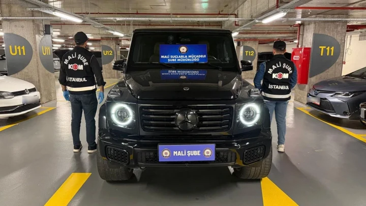 Mali Suçlarla Mücadele ekipleri, otoparkta siyah bir aracın yanında