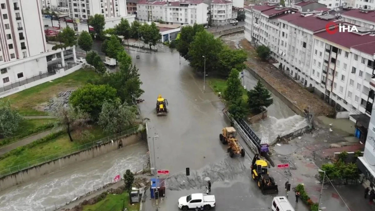 İstanbul’da taşkın nedeniyle su altında kalan bir sokakta iş makineleri çalışma yürütüyor