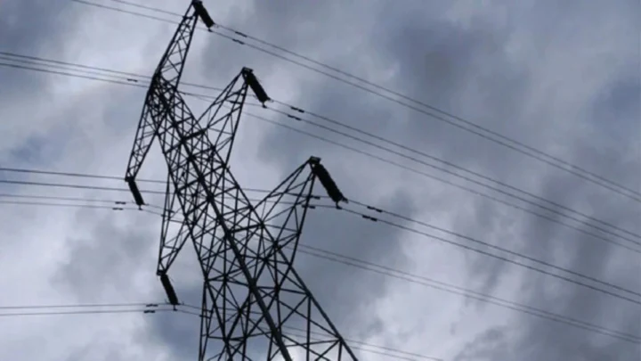 Bulutlu gökyüzü önünde yüksek gerilim elektrik direği ve enerji hatları