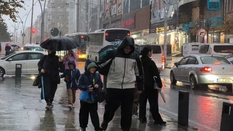 Yağmurlu havada İstanbul’da şemsiyeyle yürüyen yayalar ve trafikteki araçlar