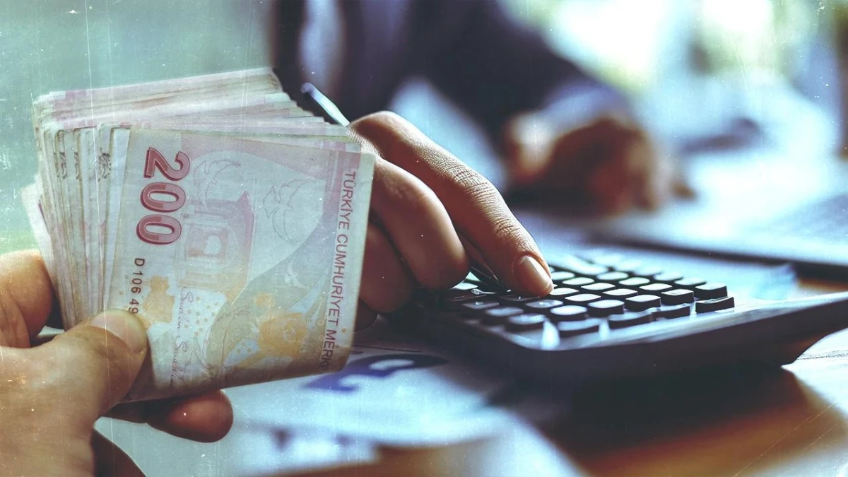 Bir el banknotları tutarken diğer el klavyede işlem yapıyor