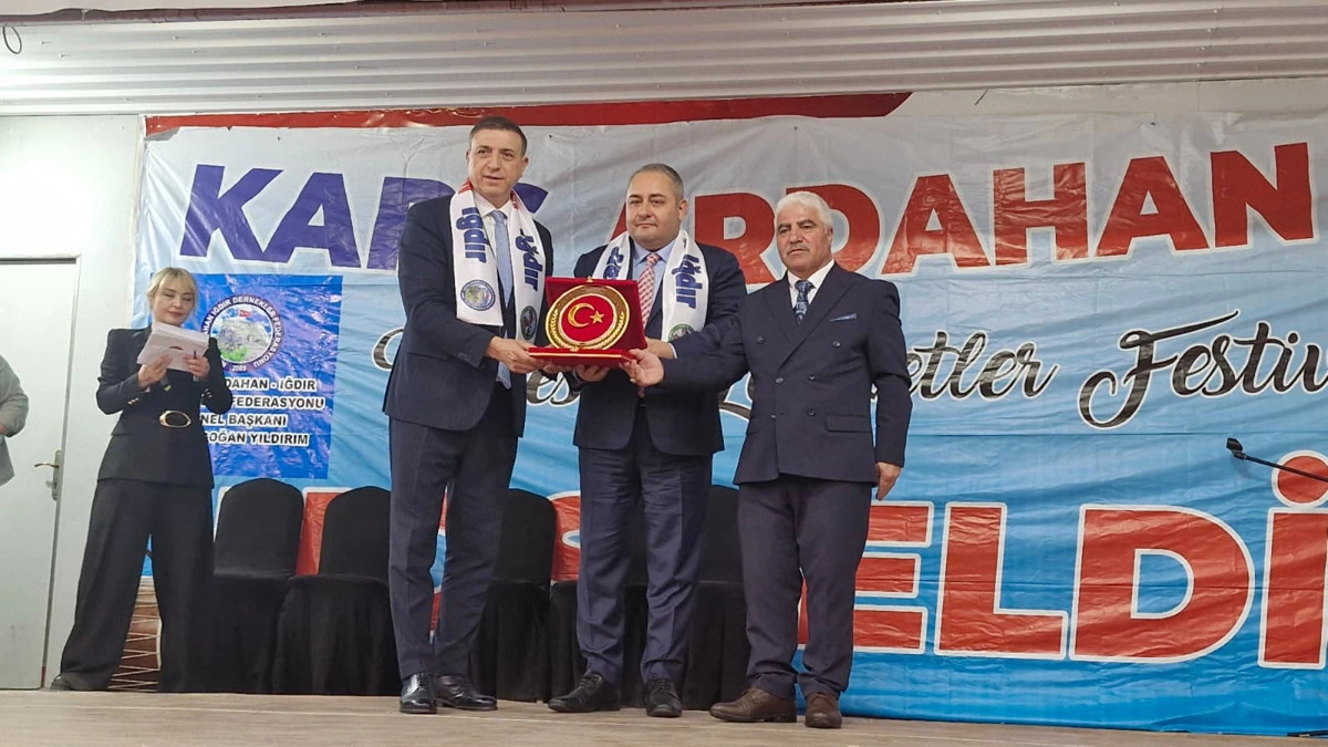 Tanıtım günleri sahnesinde plaket sunumu yapan üç kişi