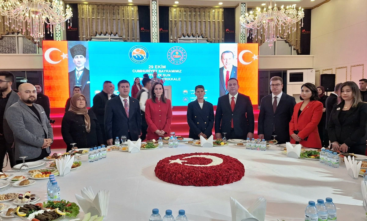 Kırıkkale’deki resepsiyonda davetliler, Türk bayrakları ve Cumhuriyet temalı ekran önünde poz veriyor.