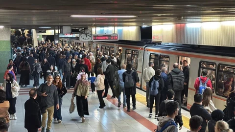 Metro istasyonunda trenin yanında bekleyen yolcular